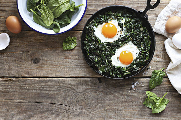 Huevos al plato con hojas verdes