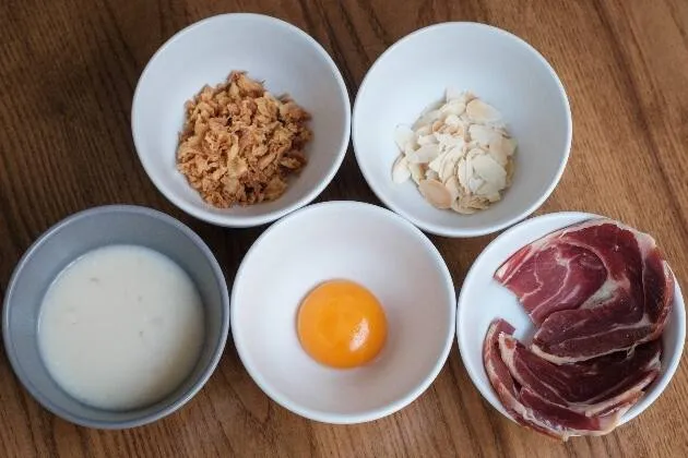 Carxofes brasejades al vi blanc amb vinagreta de pernil ibèric, rovell d'ou, ametlla i ceba cruixent