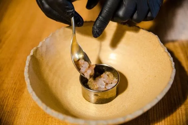 Berenjena a la llama, gamba blanca en grasa de txuleta madurada y caldo de cebollas asadas