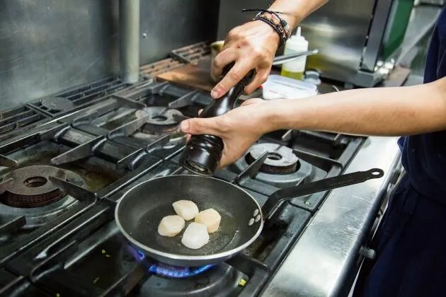 Vieires a la brasa amb crema de pèsols, coco i oli cítric