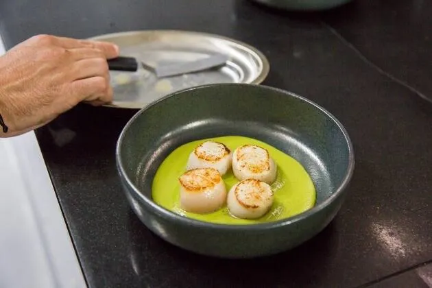 Vieires a la brasa amb crema de pèsols, coco i oli cítric