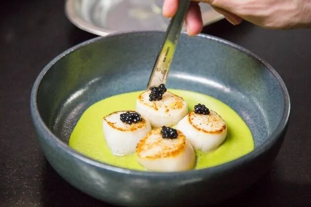 Vieires a la brasa amb crema de pèsols, coco i oli cítric