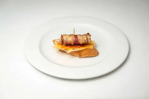Rotllo de bacon sobre llit de formatge