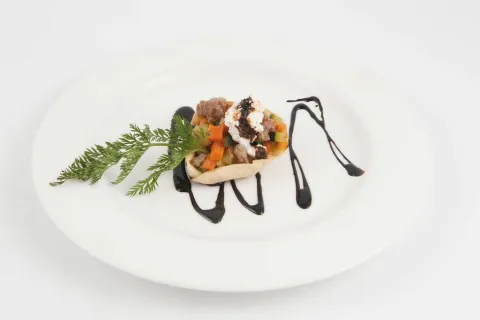 Cassoleta de botifarra, ricotta i verdures caramel·litzades