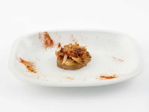 Crujiente de alcachofa, romesco y cebolla caramelizada
