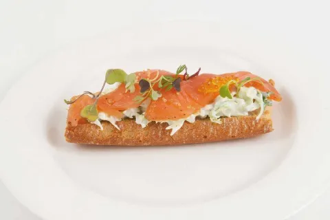 Barqueta de salmó curat sobre llit d'escarola i salsa de iogurt