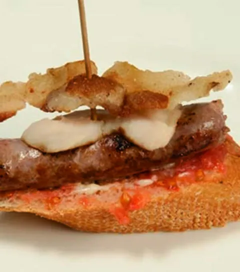 Pinxo de botifarra amb puré de mongetes seques, cruixent de cansalada i allioli
