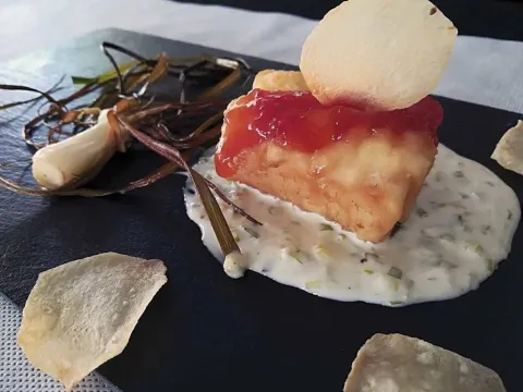 Dado de bacalao con salsa de ajos tiernos y con salsa de ajos tiernos y confitura de tomate y chips 'nyàmera'