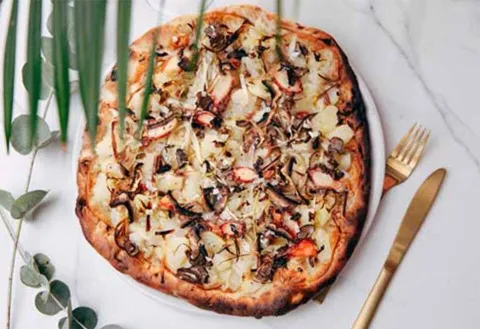 Pizza de pop, formatge fumat, porros, bolets, oli de tòfona i patates
